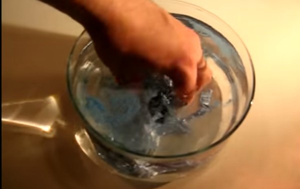 mão mechendo em água com o produto